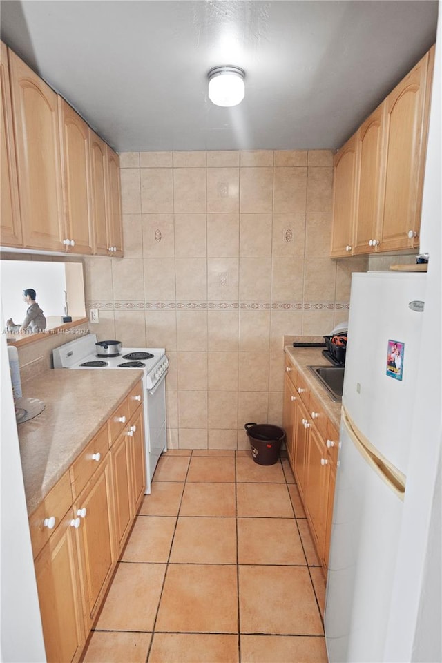 kitchen featuring tile walls, light brown cabinetry, light tile patterned floors, and white appliances