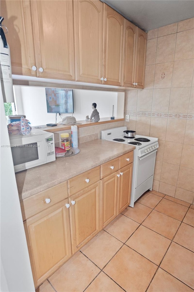 kitchen featuring light brown cabinets, white appliances, tile walls, and light tile patterned floors