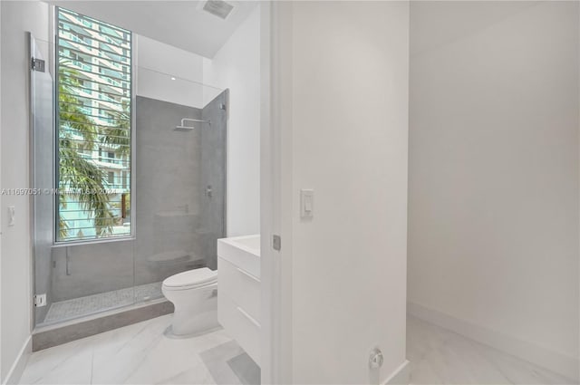 bathroom with walk in shower, a wealth of natural light, vanity, and toilet