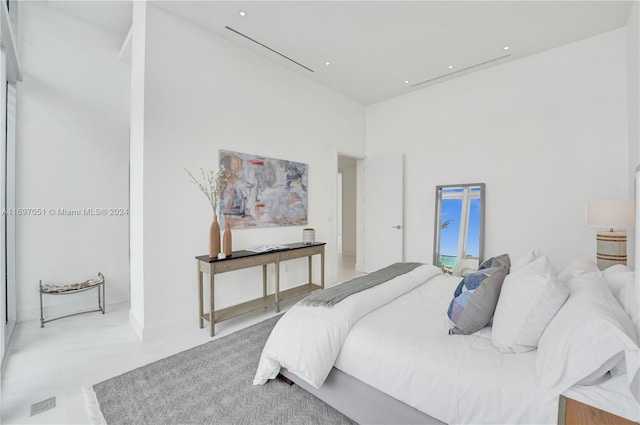 bedroom with light tile patterned flooring and a towering ceiling