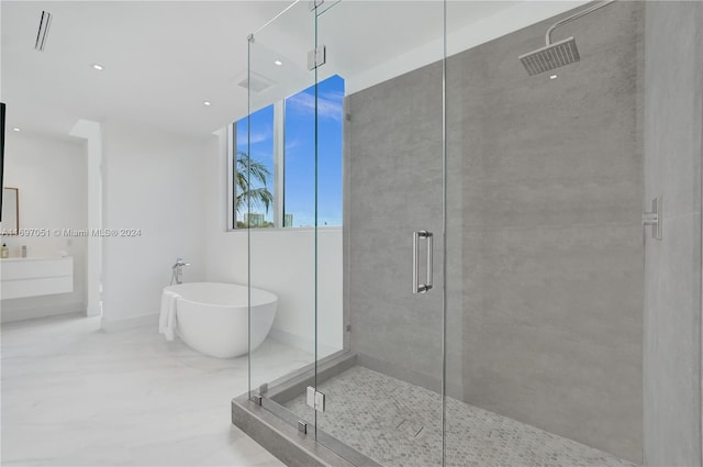 bathroom featuring vanity and shower with separate bathtub