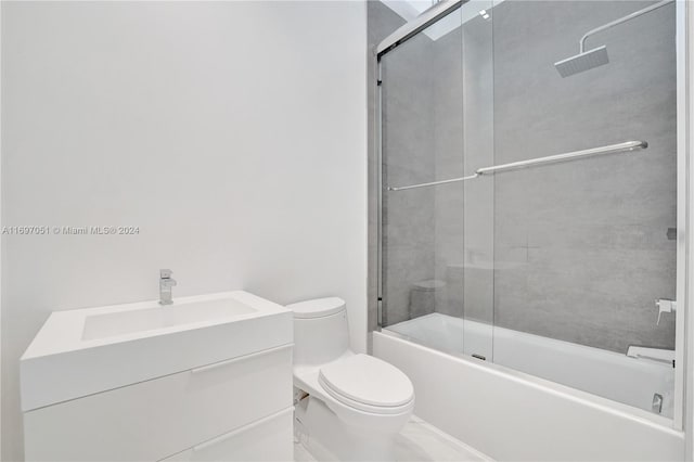 full bathroom with shower / bath combination with glass door, vanity, and toilet