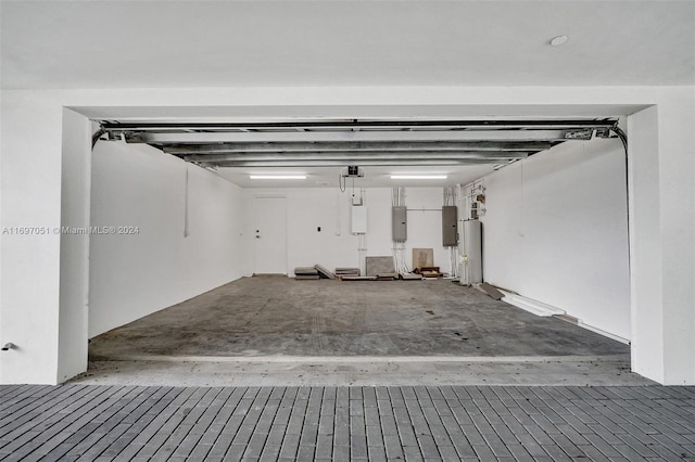 garage featuring electric panel and water heater