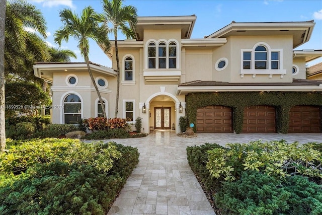 mediterranean / spanish-style house with a garage and french doors