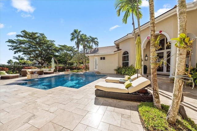 view of pool with pool water feature and a patio