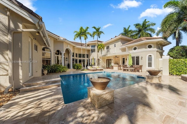 view of pool with ceiling fan and a patio