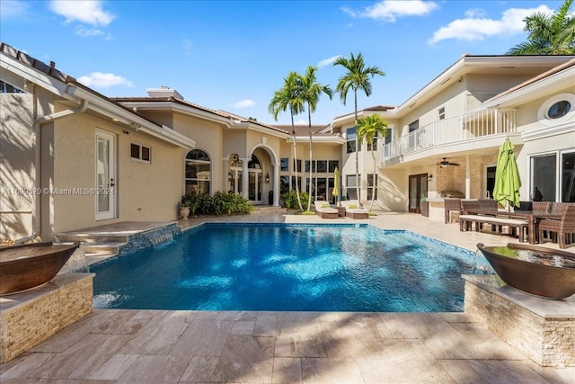 view of swimming pool with pool water feature, ceiling fan, and a patio area