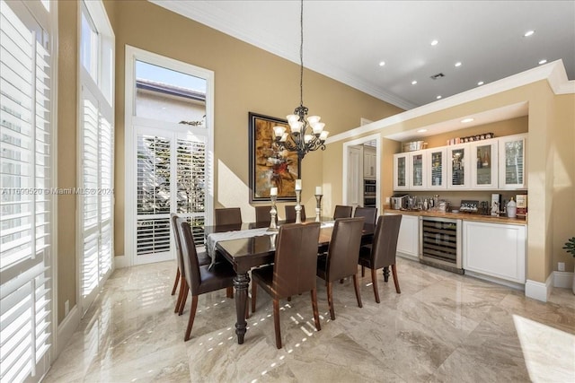 dining room with an inviting chandelier, ornamental molding, beverage cooler, and indoor bar