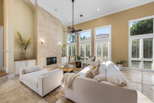 living room featuring a high end fireplace, a high ceiling, ceiling fan, and crown molding