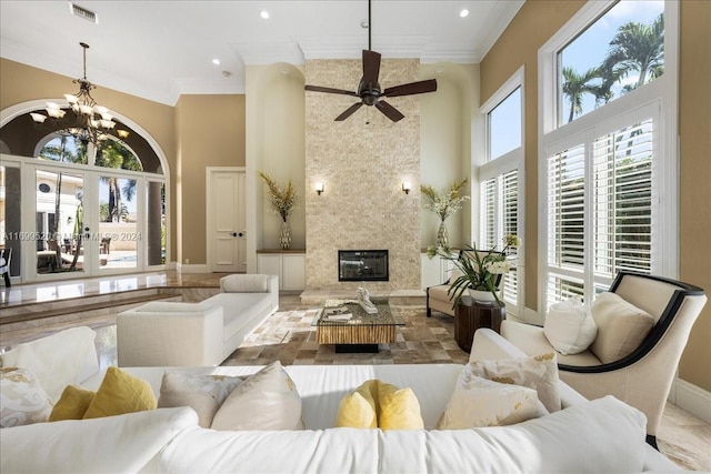 living room featuring a high ceiling, ceiling fan with notable chandelier, french doors, and crown molding