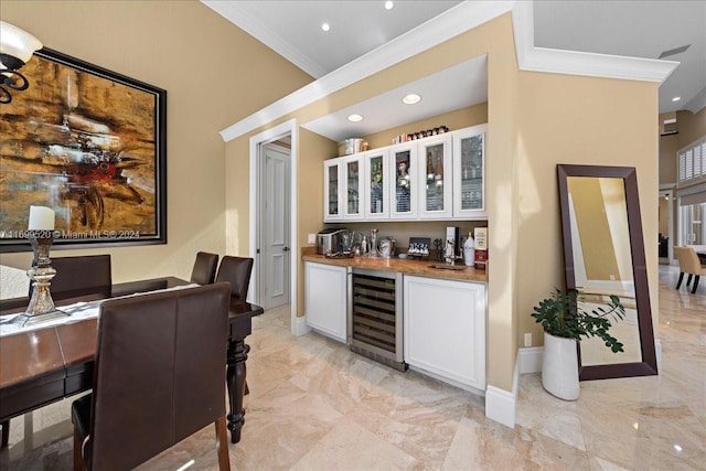 bar with wine cooler, crown molding, white cabinets, and butcher block counters