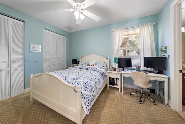 bedroom with ceiling fan and two closets