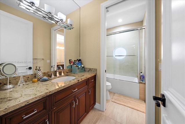 full bathroom featuring tile patterned flooring, vanity, toilet, and bath / shower combo with glass door