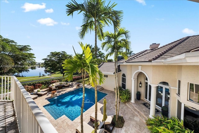 view of pool with a water view and a patio area