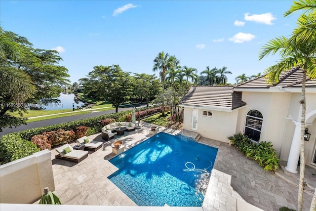 view of swimming pool with a water view and a patio area