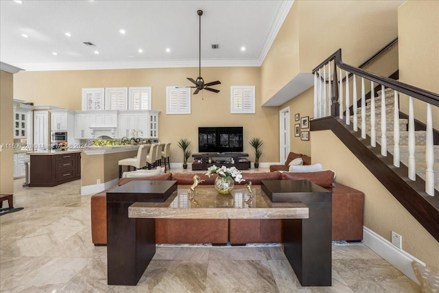 living room with ceiling fan and crown molding