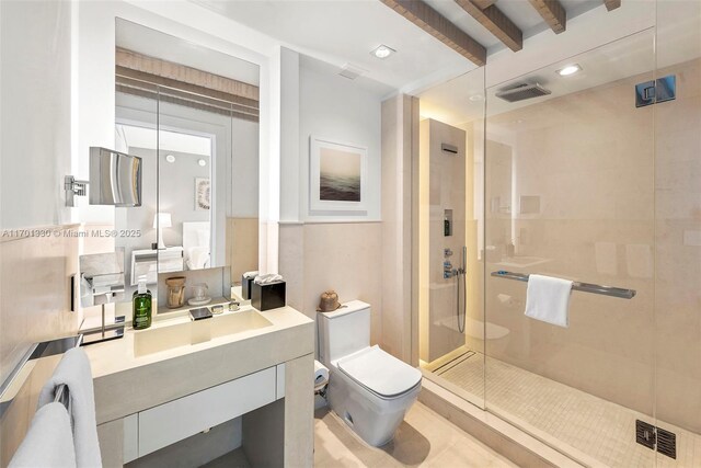 bathroom featuring vanity, beamed ceiling, a shower with door, and toilet