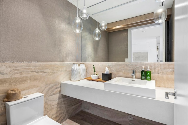 bathroom featuring vanity, tile walls, and toilet