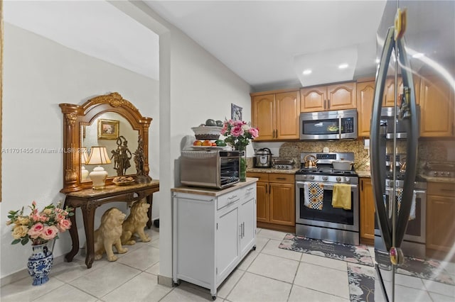 kitchen featuring tasteful backsplash, light tile patterned flooring, and appliances with stainless steel finishes