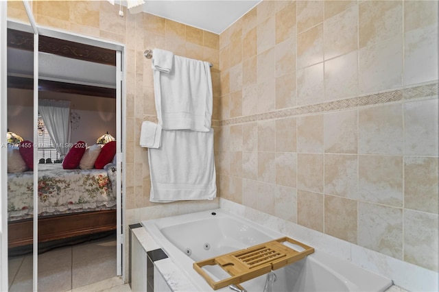 bathroom with tiled tub, tile patterned flooring, and tile walls