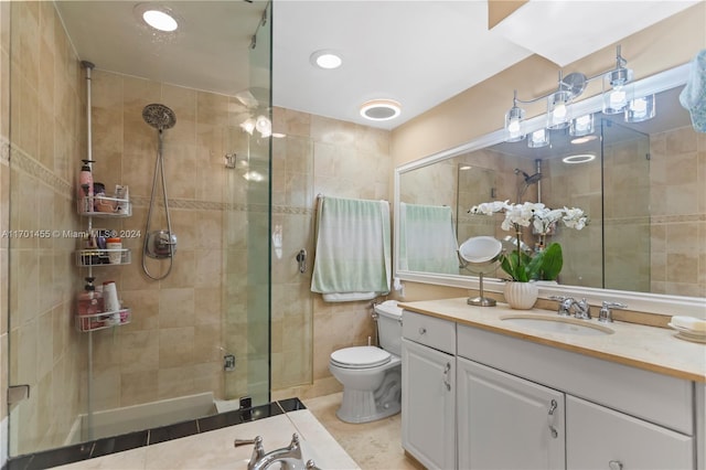 bathroom featuring tile patterned flooring, vanity, toilet, and walk in shower