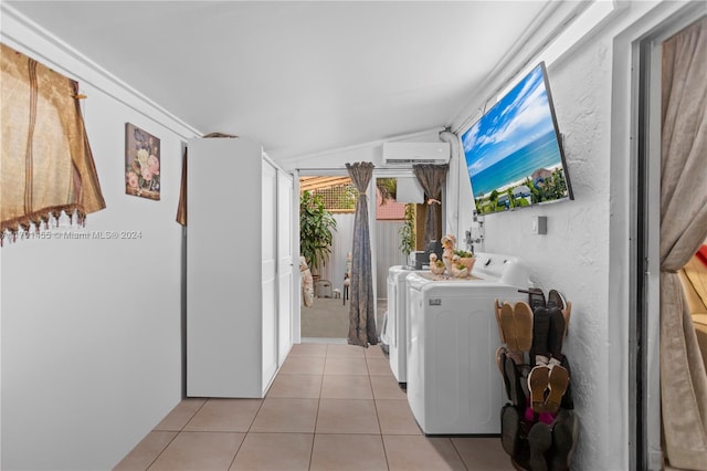 washroom with independent washer and dryer, light tile patterned floors, and a wall mounted AC