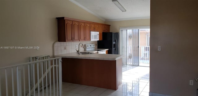 kitchen featuring kitchen peninsula, a textured ceiling, white appliances, vaulted ceiling, and crown molding