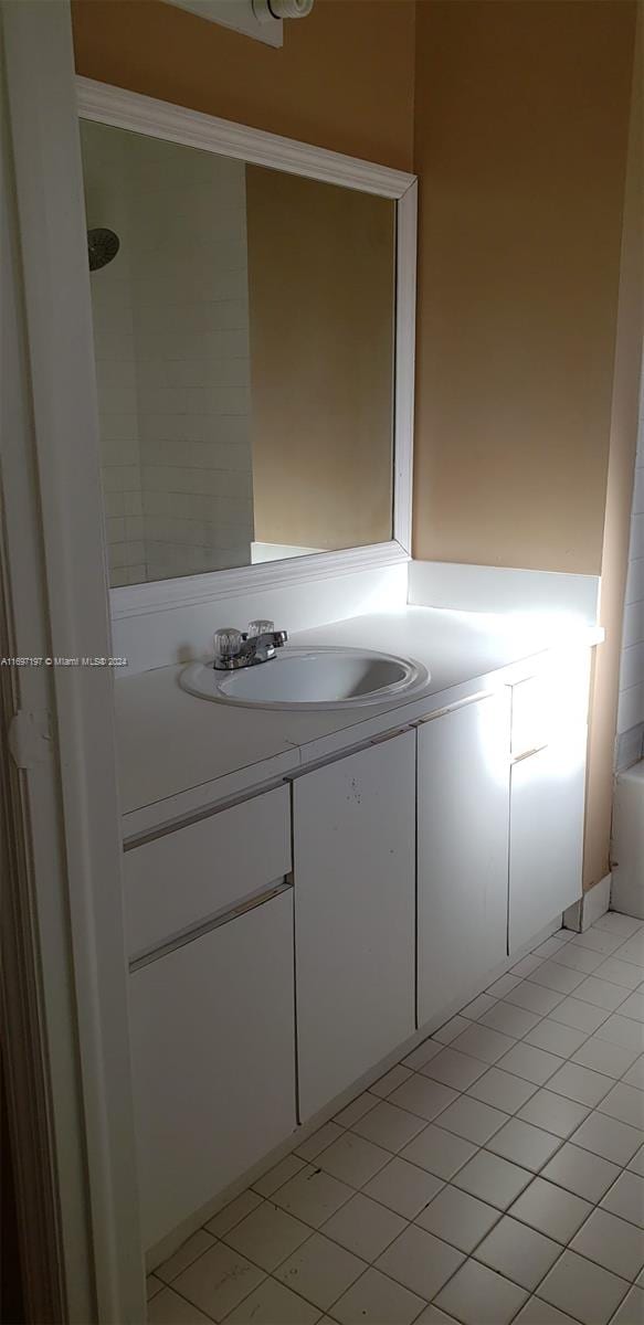 bathroom featuring tile patterned floors, a bathtub, and vanity