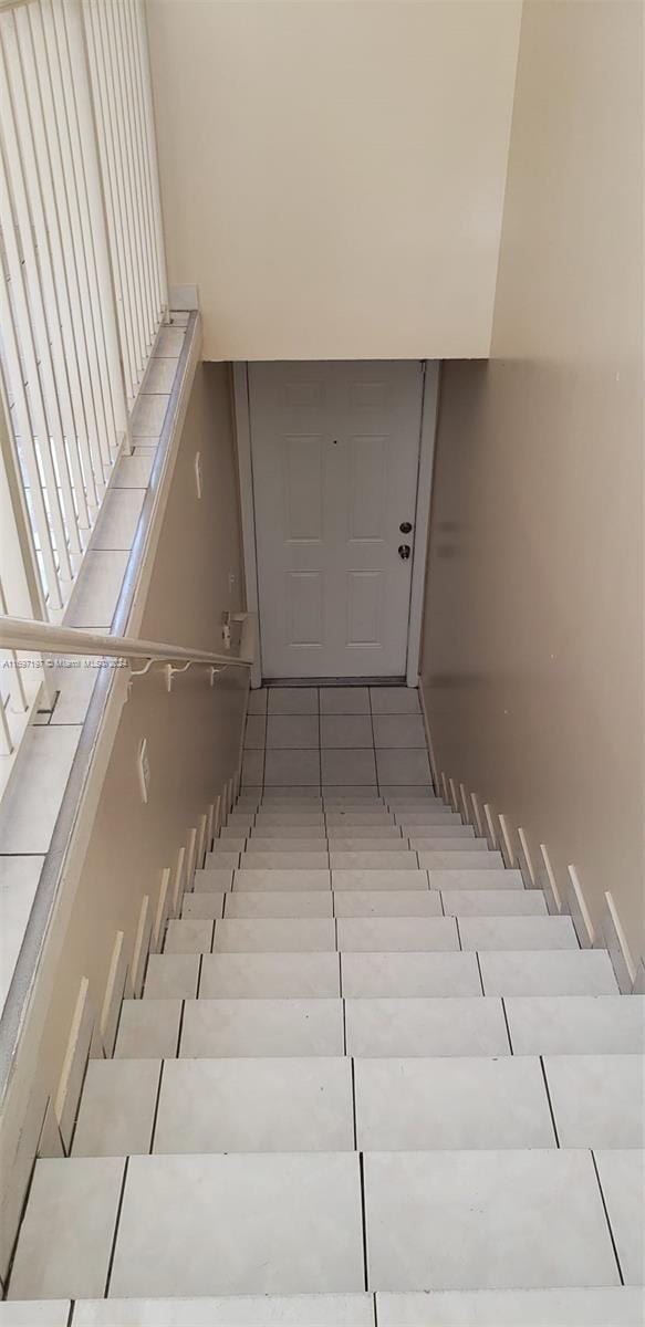 stairway with tile patterned floors