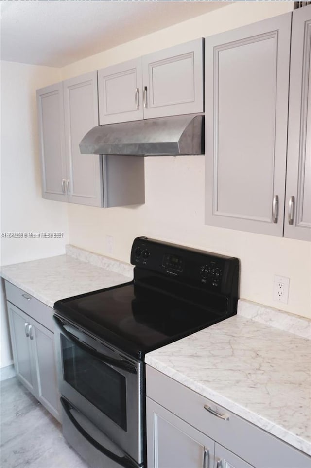 kitchen featuring gray cabinets, electric range, light hardwood / wood-style flooring, and light stone countertops