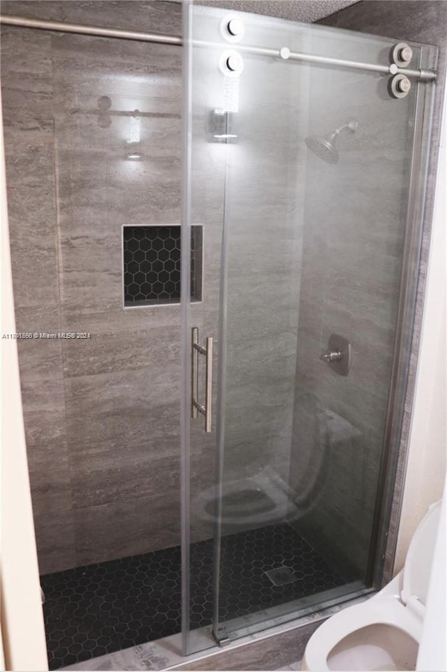 bathroom featuring an enclosed shower and toilet