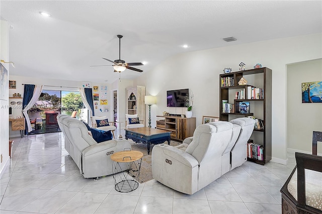 living room with ceiling fan, light tile patterned flooring, and vaulted ceiling