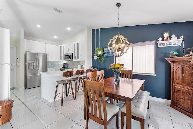 tiled dining room featuring lofted ceiling and an inviting chandelier