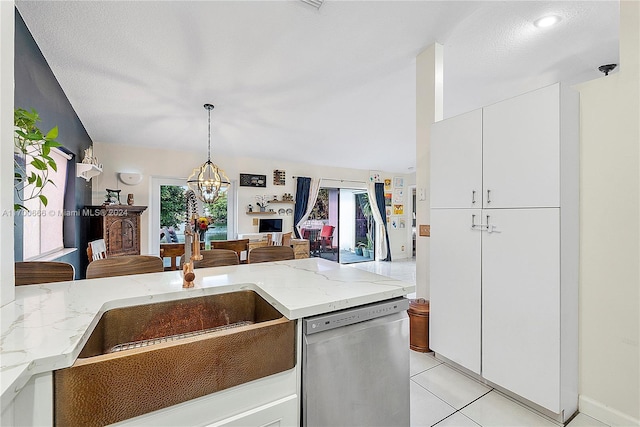 kitchen with light stone countertops, an inviting chandelier, dishwasher, white cabinetry, and light tile patterned flooring