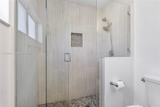 bathroom with toilet and a shower with shower door