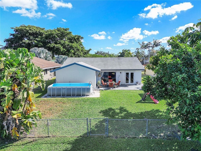 back of house with a fenced in pool, french doors, and a yard