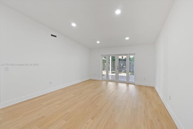 spare room with french doors and light hardwood / wood-style floors