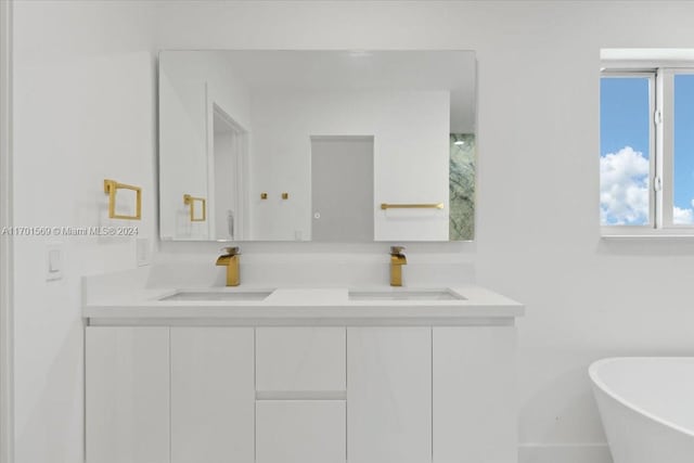 bathroom with a tub to relax in and vanity