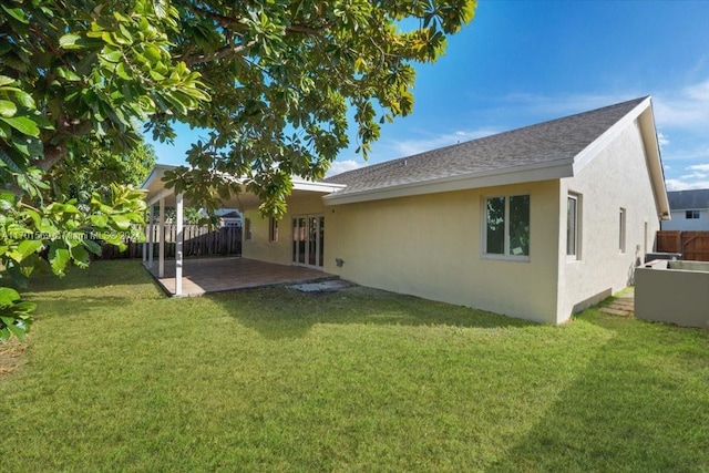 rear view of property with a lawn and a patio