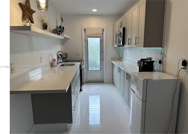 kitchen with decorative backsplash, white cabinetry, sink, and appliances with stainless steel finishes