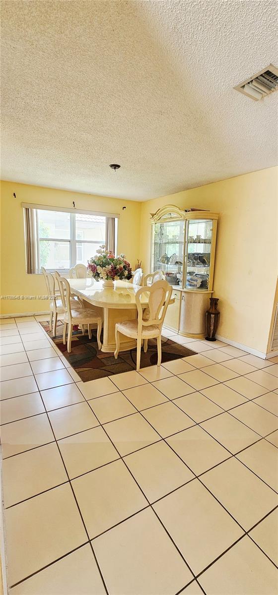 17352 SW 18th St, Miramar, FL 33029 - dining space with a textured ceiling and light tile patterned flooring