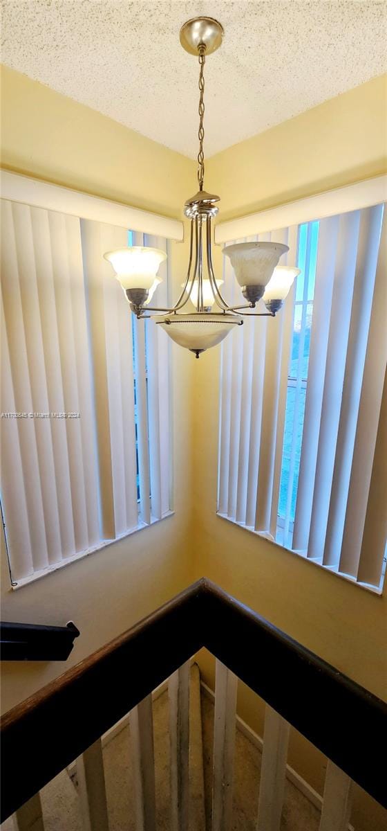 room details featuring a textured ceiling and a notable chandelier