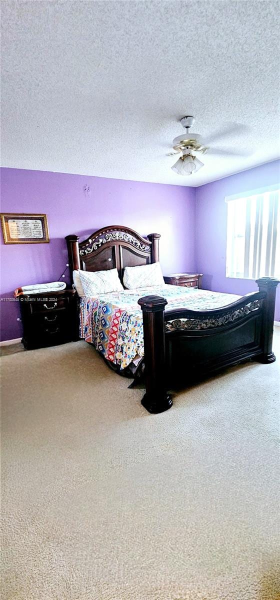 bedroom with a textured ceiling, carpet floors, and ceiling fan