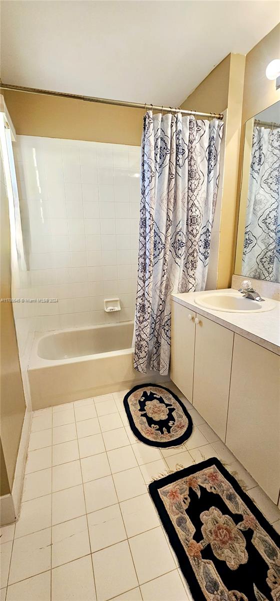 bathroom with tile patterned floors, vanity, and shower / bathtub combination with curtain