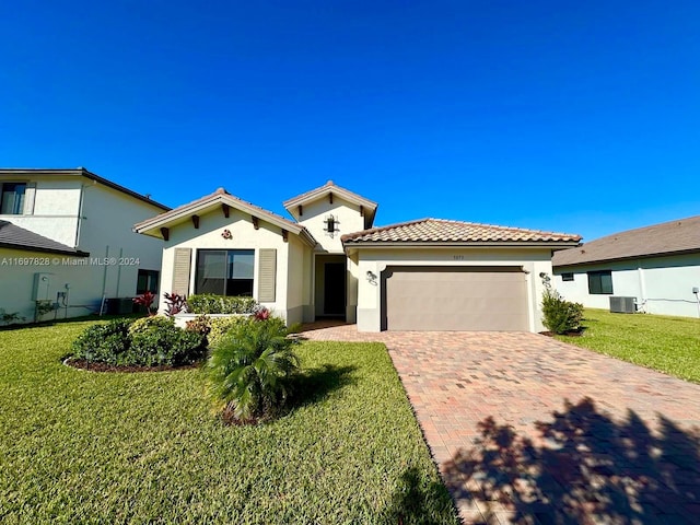 mediterranean / spanish-style house with central AC, a garage, and a front lawn