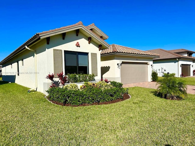 mediterranean / spanish house featuring a front lawn and a garage