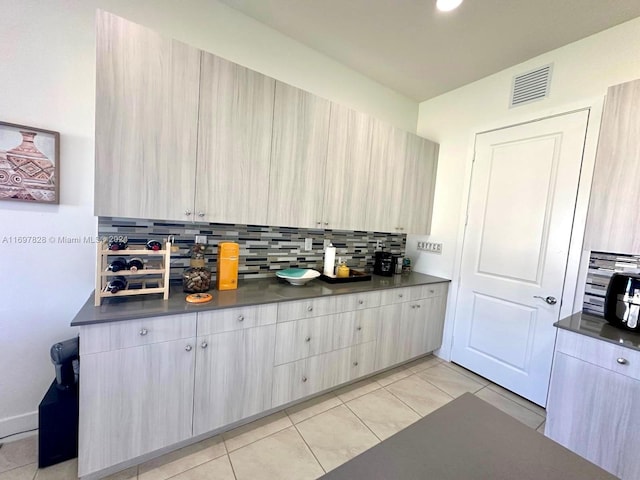 kitchen with tasteful backsplash, light brown cabinets, and light tile patterned floors