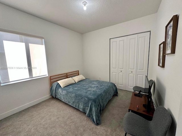 carpeted bedroom featuring a textured ceiling and a closet