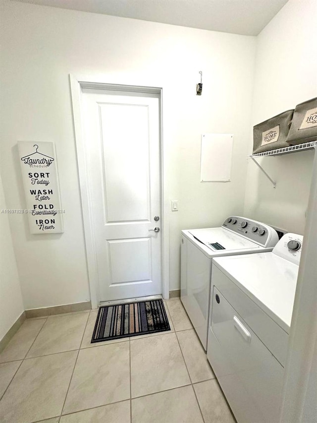 clothes washing area with separate washer and dryer and light tile patterned floors