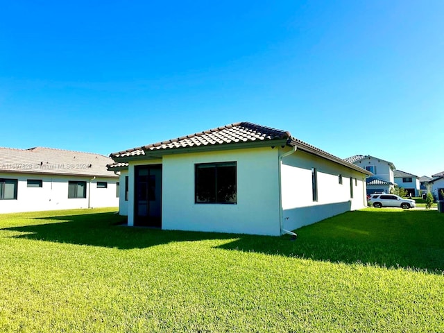 rear view of house featuring a yard